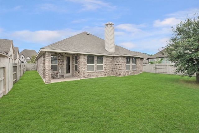 back of house featuring a patio and a lawn