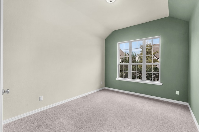 carpeted spare room with lofted ceiling