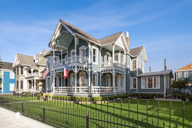 view of front facade featuring a balcony and a front yard