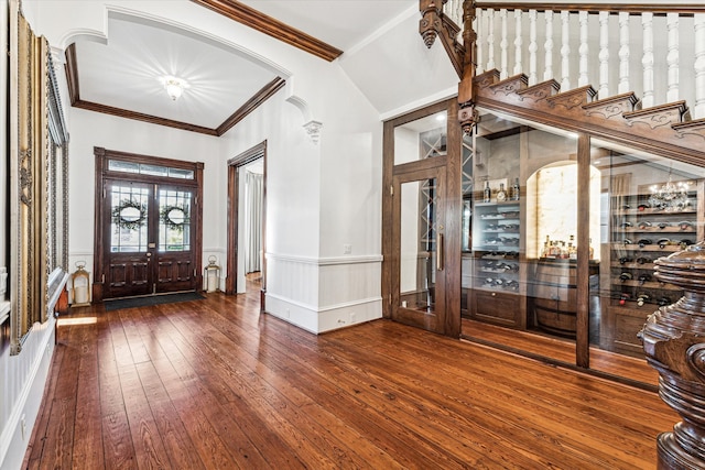 foyer entrance with french doors, crown molding, vaulted ceiling, and hardwood / wood-style floors