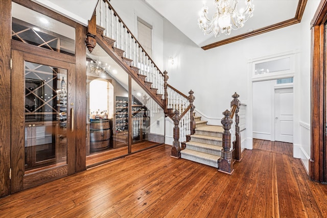 foyer entrance with crown molding and hardwood / wood-style floors