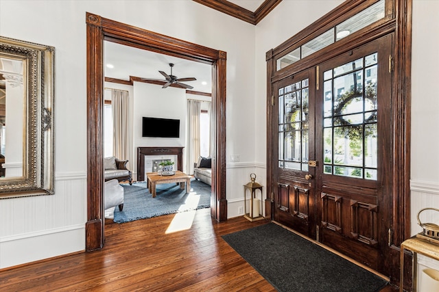 entryway with ornamental molding, dark wood-type flooring, and ceiling fan