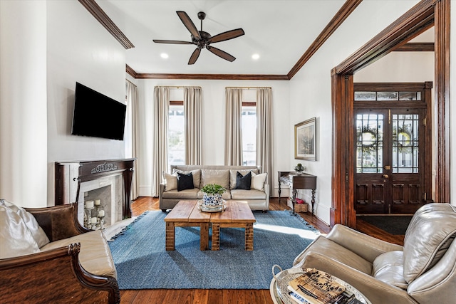 living room with ornamental molding, hardwood / wood-style flooring, a fireplace, and a wealth of natural light