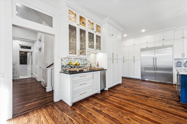 kitchen featuring white cabinetry, dark hardwood / wood-style floors, tasteful backsplash, and built in fridge