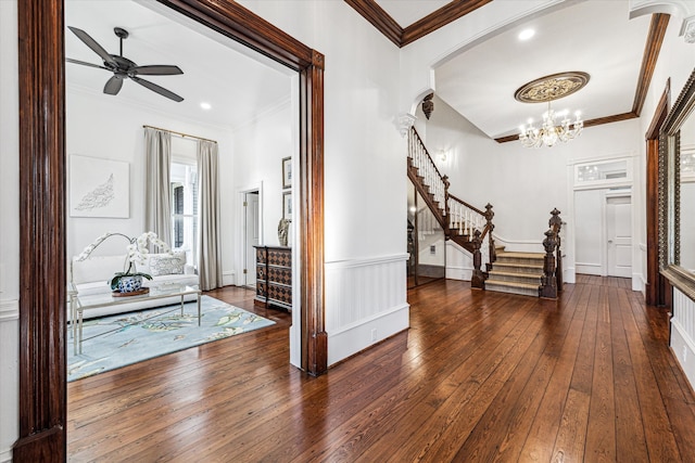 foyer featuring ornamental molding, dark hardwood / wood-style flooring, and ceiling fan with notable chandelier