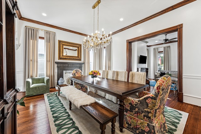 dining room with ceiling fan with notable chandelier, crown molding, plenty of natural light, and dark hardwood / wood-style floors