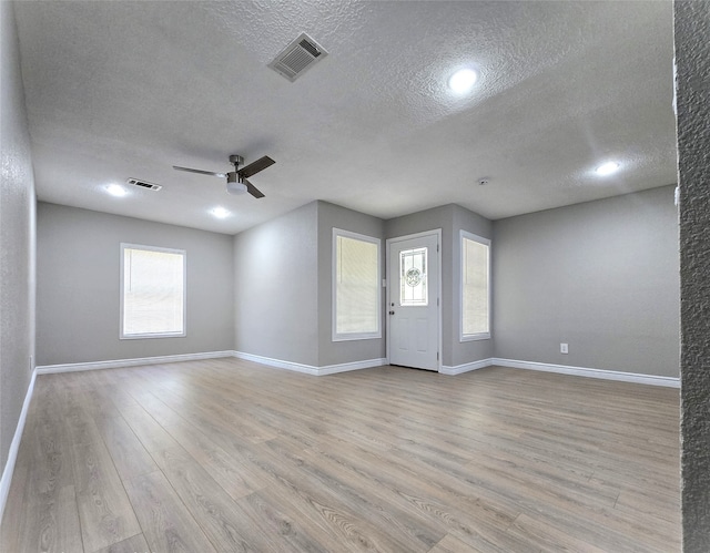 interior space featuring ceiling fan, a textured ceiling, and light wood-type flooring