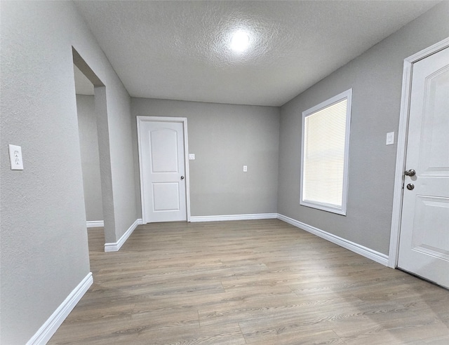 foyer featuring a textured ceiling and light wood-type flooring