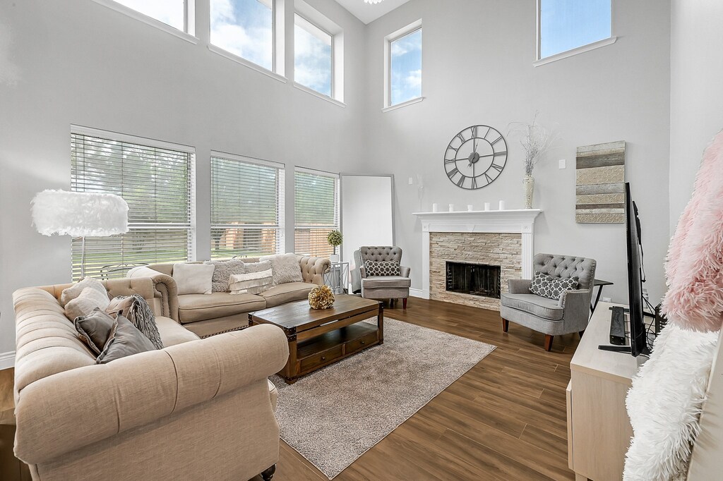 living room featuring dark hardwood / wood-style floors, a healthy amount of sunlight, and a high ceiling