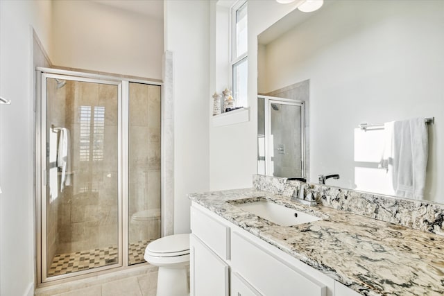 bathroom with vanity, a healthy amount of sunlight, tile patterned flooring, toilet, and a shower with shower door