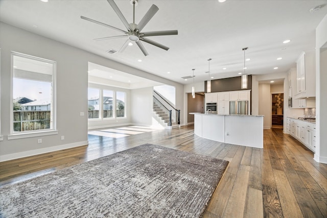 unfurnished living room with ceiling fan and hardwood / wood-style flooring