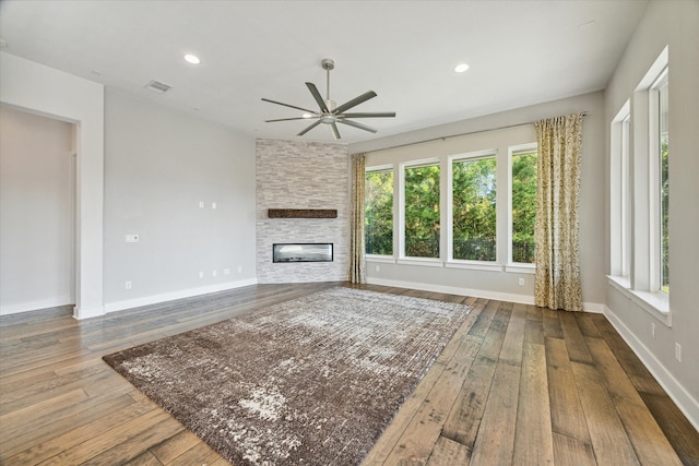 unfurnished living room featuring a fireplace, wood-type flooring, and ceiling fan