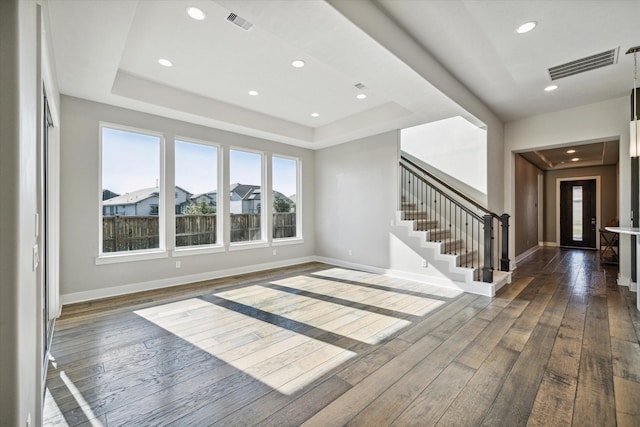 unfurnished living room with french doors, dark wood-type flooring, and a tray ceiling