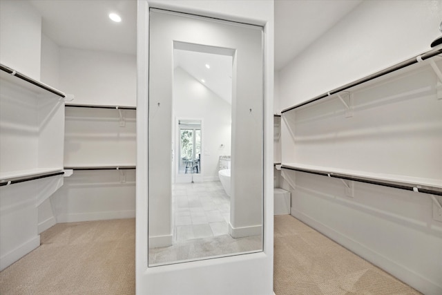 spacious closet featuring light carpet and vaulted ceiling