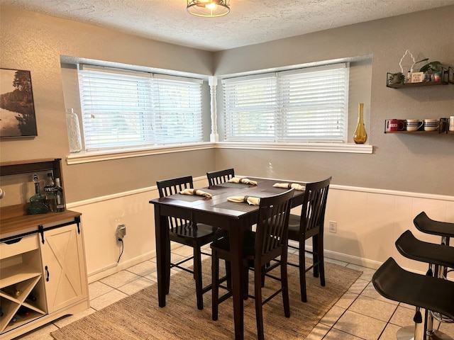 tiled dining room with a textured ceiling