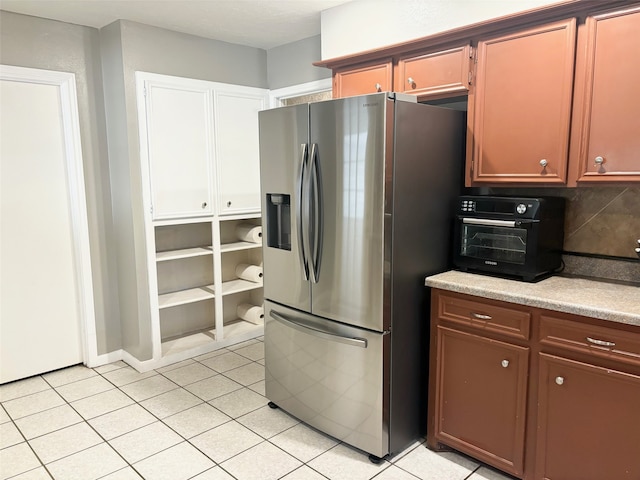 kitchen with stainless steel fridge, tasteful backsplash, and light tile patterned flooring