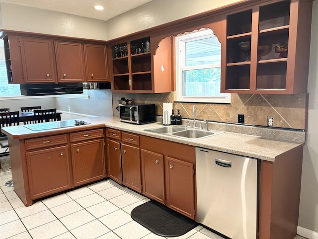 kitchen featuring sink, light tile patterned flooring, kitchen peninsula, stainless steel appliances, and decorative backsplash