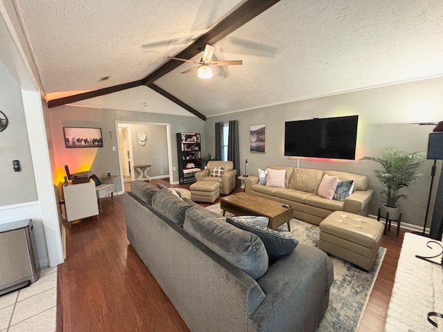 living room featuring ceiling fan, lofted ceiling with beams, a textured ceiling, and hardwood / wood-style floors