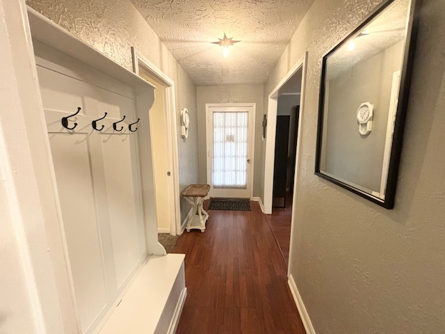 mudroom with a textured ceiling and dark hardwood / wood-style flooring