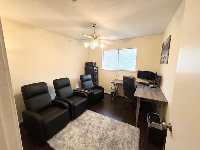 office with ceiling fan, a textured ceiling, and dark hardwood / wood-style flooring