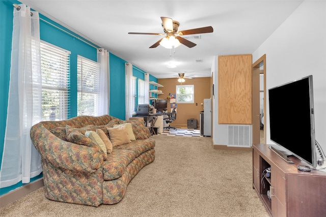 living room featuring light colored carpet, a healthy amount of sunlight, and ceiling fan