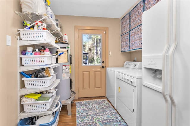 clothes washing area featuring water heater, separate washer and dryer, and light wood-type flooring