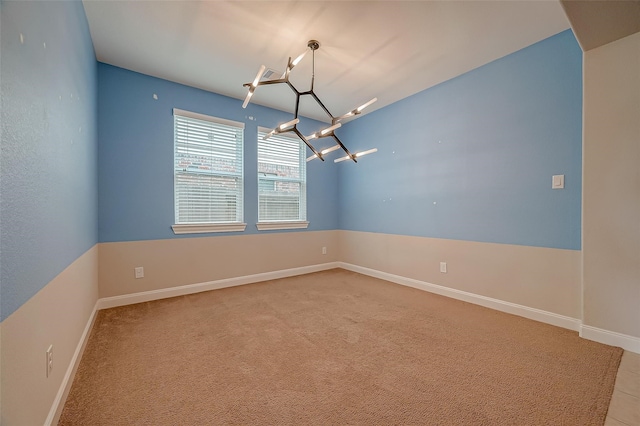 unfurnished room with an inviting chandelier and light colored carpet