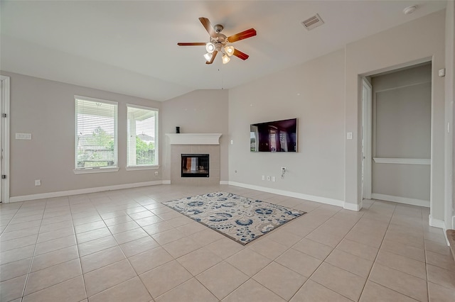 unfurnished living room featuring lofted ceiling, light tile patterned floors, a fireplace, and ceiling fan