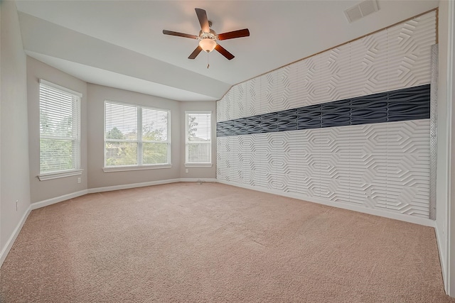 carpeted spare room featuring ceiling fan and lofted ceiling