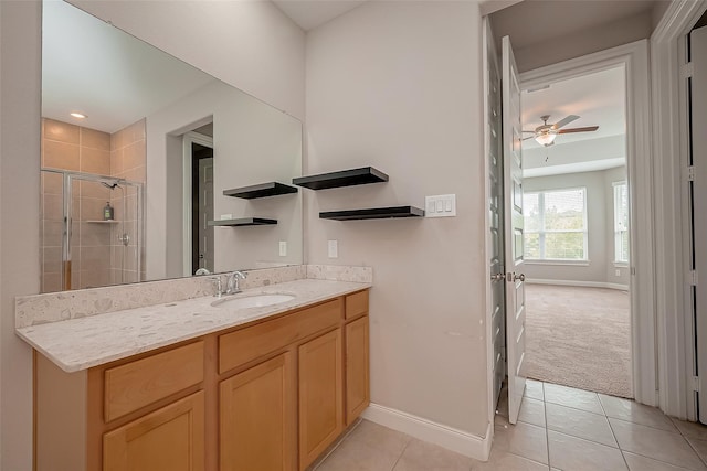 bathroom with a shower with door, vanity, ceiling fan, and tile patterned flooring