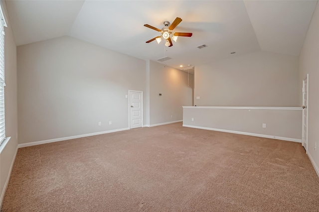 empty room featuring vaulted ceiling, carpet flooring, and ceiling fan