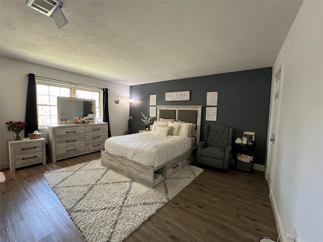 bedroom with dark wood-type flooring and a textured ceiling