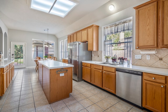 kitchen featuring sink, a center island, tasteful backsplash, decorative light fixtures, and appliances with stainless steel finishes