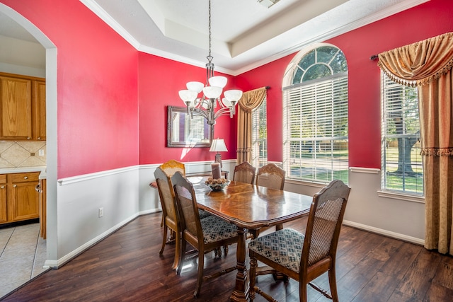 dining room with plenty of natural light, dark hardwood / wood-style floors, a chandelier, and a tray ceiling