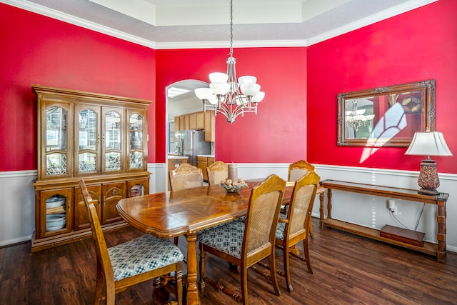 dining space featuring ornamental molding, dark hardwood / wood-style flooring, a raised ceiling, and a notable chandelier