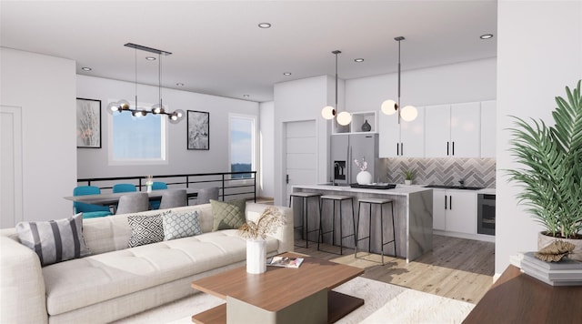 living room featuring wine cooler, a notable chandelier, and light hardwood / wood-style floors