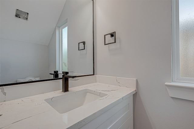 bathroom featuring vanity and lofted ceiling