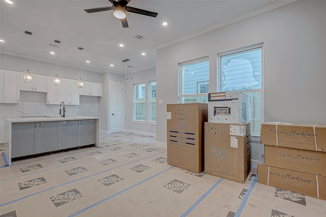 kitchen featuring decorative light fixtures, sink, and white cabinets