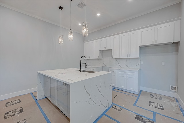 kitchen with a kitchen island with sink, hanging light fixtures, tasteful backsplash, and white cabinets