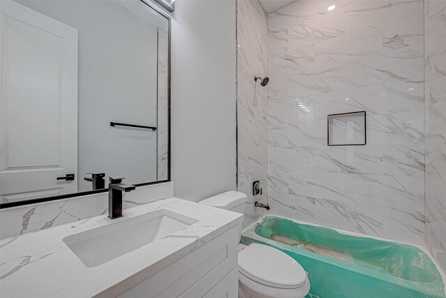 full bathroom featuring vanity, toilet, and tiled shower / bath combo