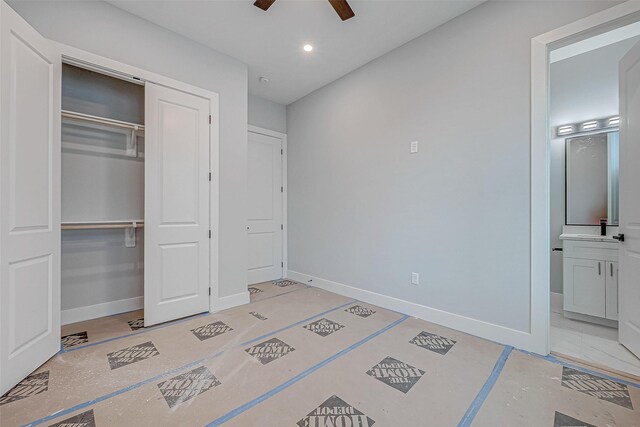 bedroom with ceiling fan, ensuite bathroom, and a closet