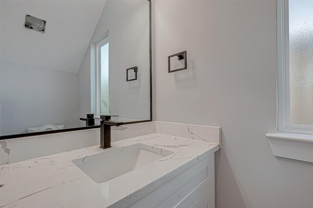 bathroom with vanity and lofted ceiling