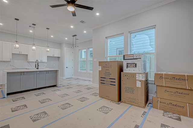 kitchen with ceiling fan, white cabinets, and hanging light fixtures