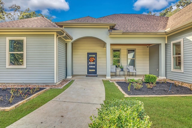 view of exterior entry with a lawn