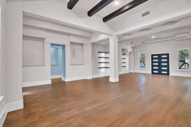 unfurnished living room with beamed ceiling and dark hardwood / wood-style floors