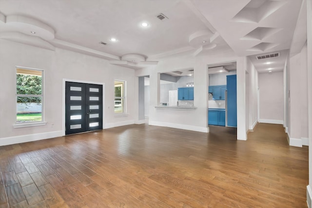 unfurnished living room with a healthy amount of sunlight and dark hardwood / wood-style floors