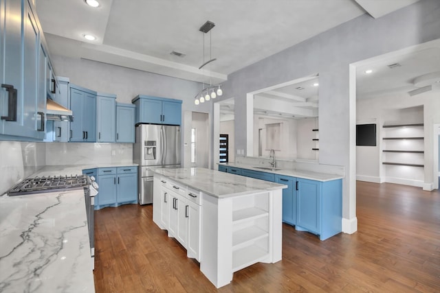 kitchen with dark hardwood / wood-style flooring, a kitchen island, light stone counters, and appliances with stainless steel finishes