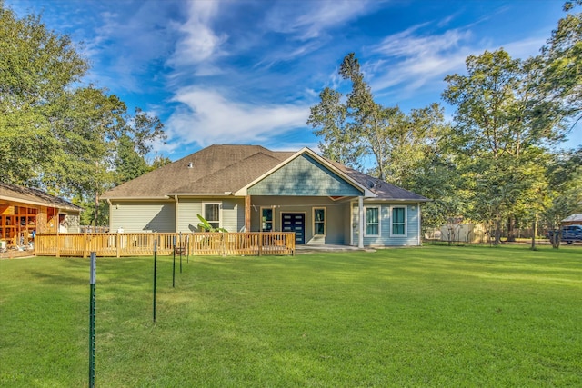 rear view of property with a wooden deck and a yard