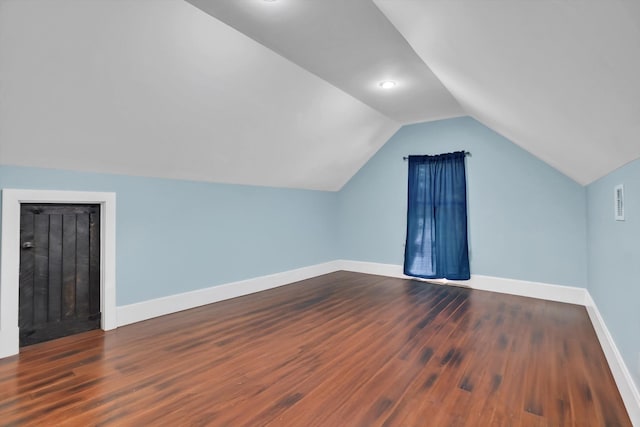 bonus room with dark hardwood / wood-style flooring and vaulted ceiling