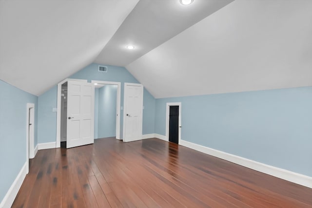 additional living space featuring vaulted ceiling and dark hardwood / wood-style floors